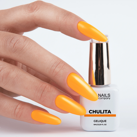 Vernis semi permanent Chulita Nails Company tenu en main avec couleur orange intense visible.