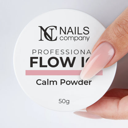 Main tenant le Flow IQ Calm Powder Nails Company avec pot fermé rose froid.