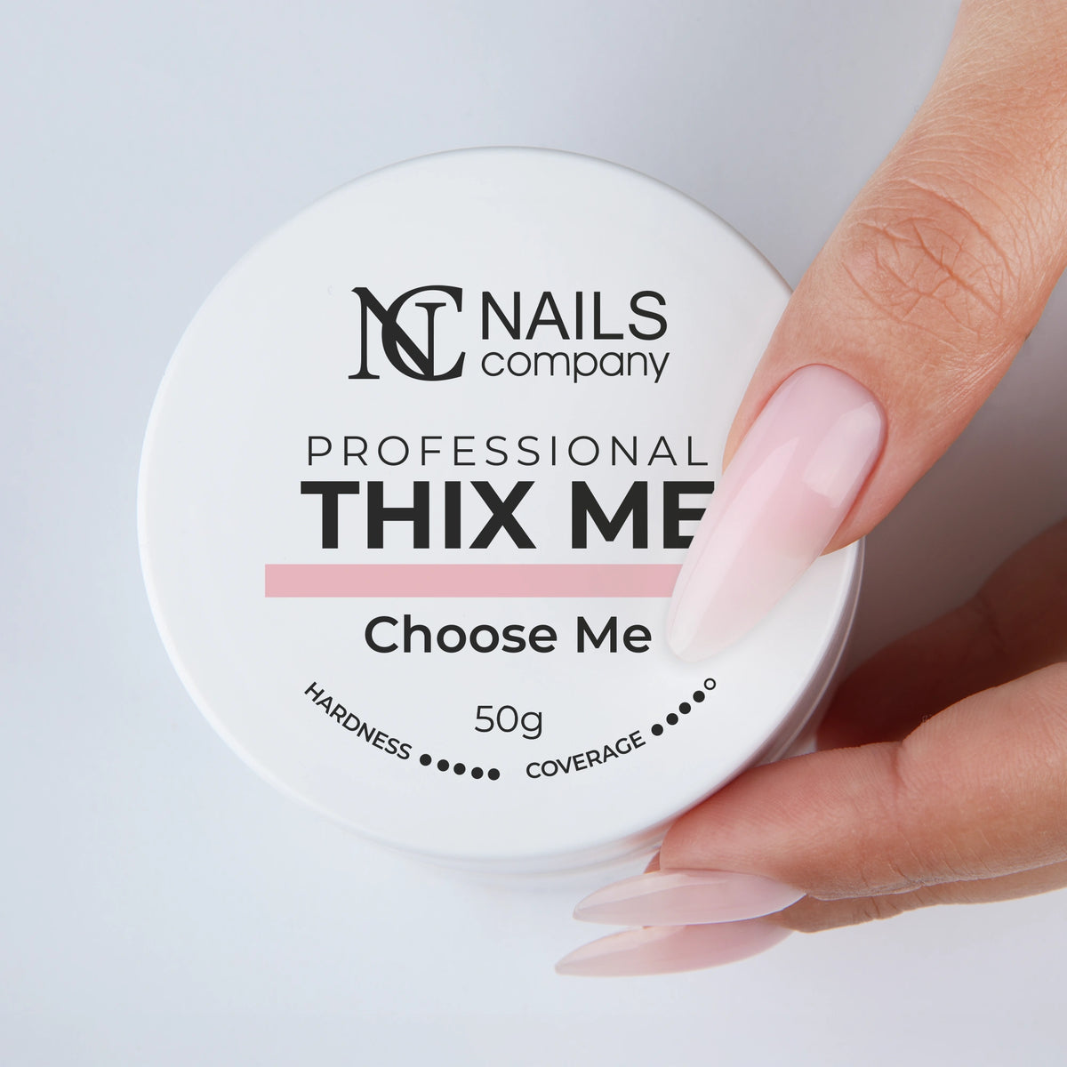 Main tenant le pot fermé de Thix Me Choose Me de Nails Company avec le gel déposé sur la main