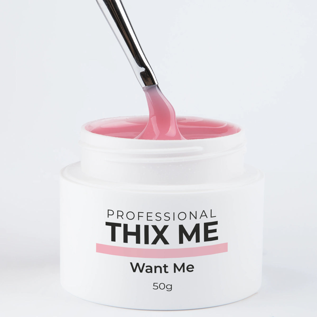 Pot ouvert du gel de construction Thix Me Want Me de Nails Company avec un pinceau tirant la matière