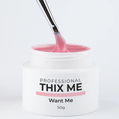 Pot ouvert du gel de construction Thix Me Want Me de Nails Company avec un pinceau tirant la matière