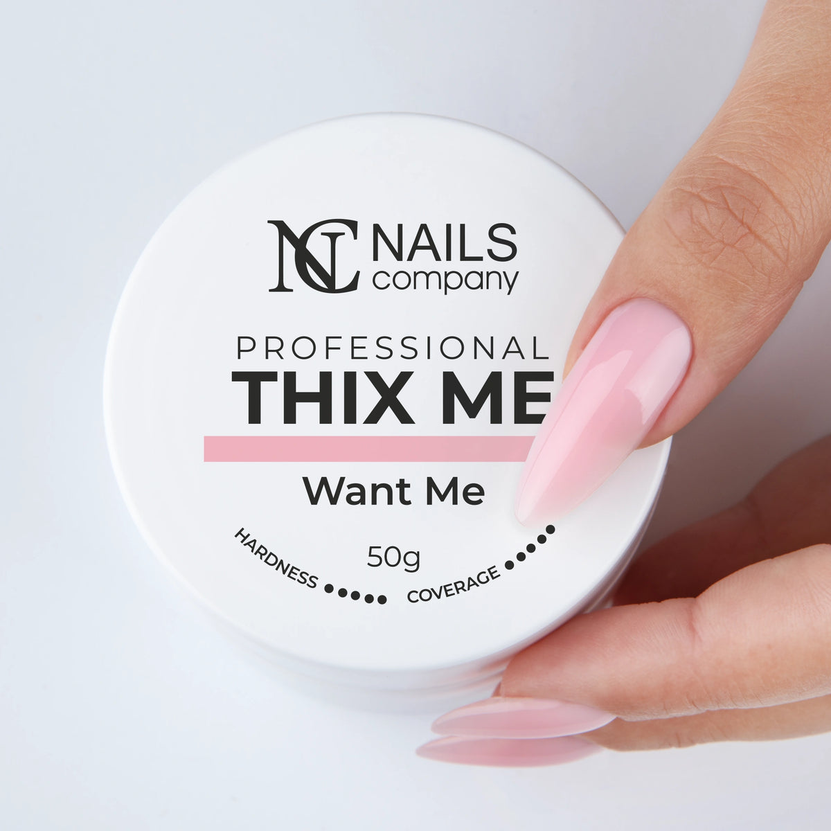Main tenant le pot fermé de Thix Me Want Me de Nails Company avec le gel déposé sur la main