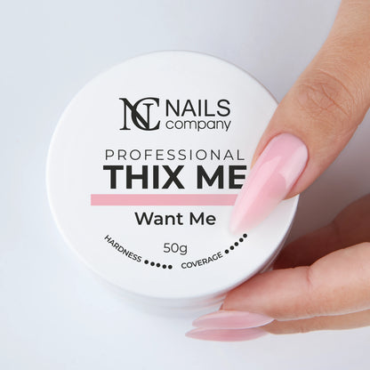 Main tenant le pot fermé de Thix Me Want Me de Nails Company avec le gel déposé sur la main