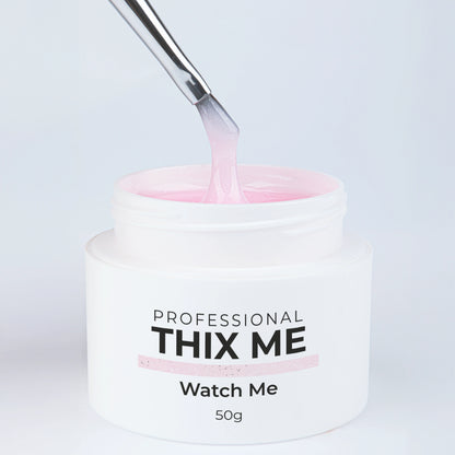 Pot ouvert du gel de construction Thix Me Watch Me de Nails Company avec un pinceau tirant la matière