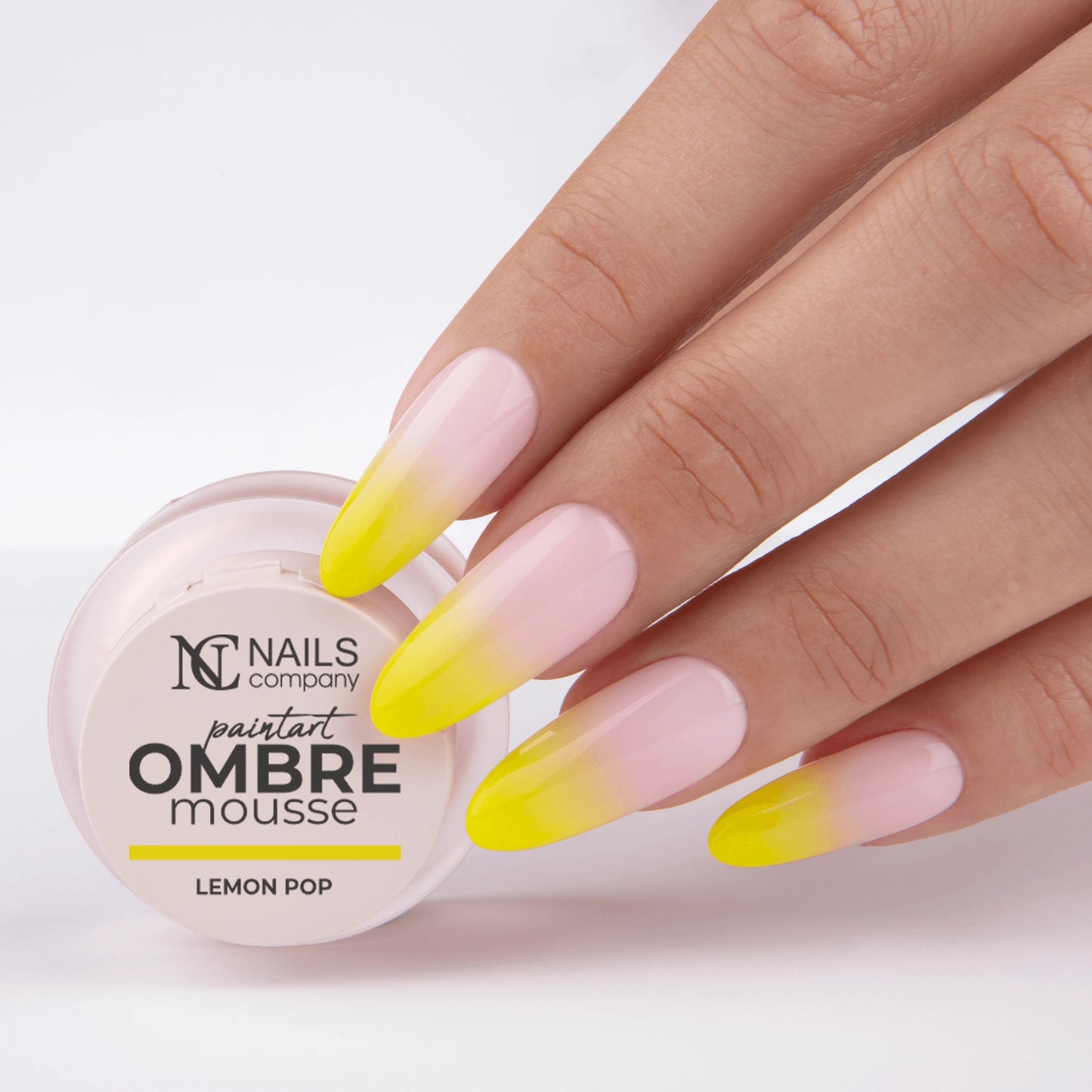Main tenant le pot de Paintart Ombre Mousse Lemon Pop de Nails Company avec le produit appliqué sur les ongles