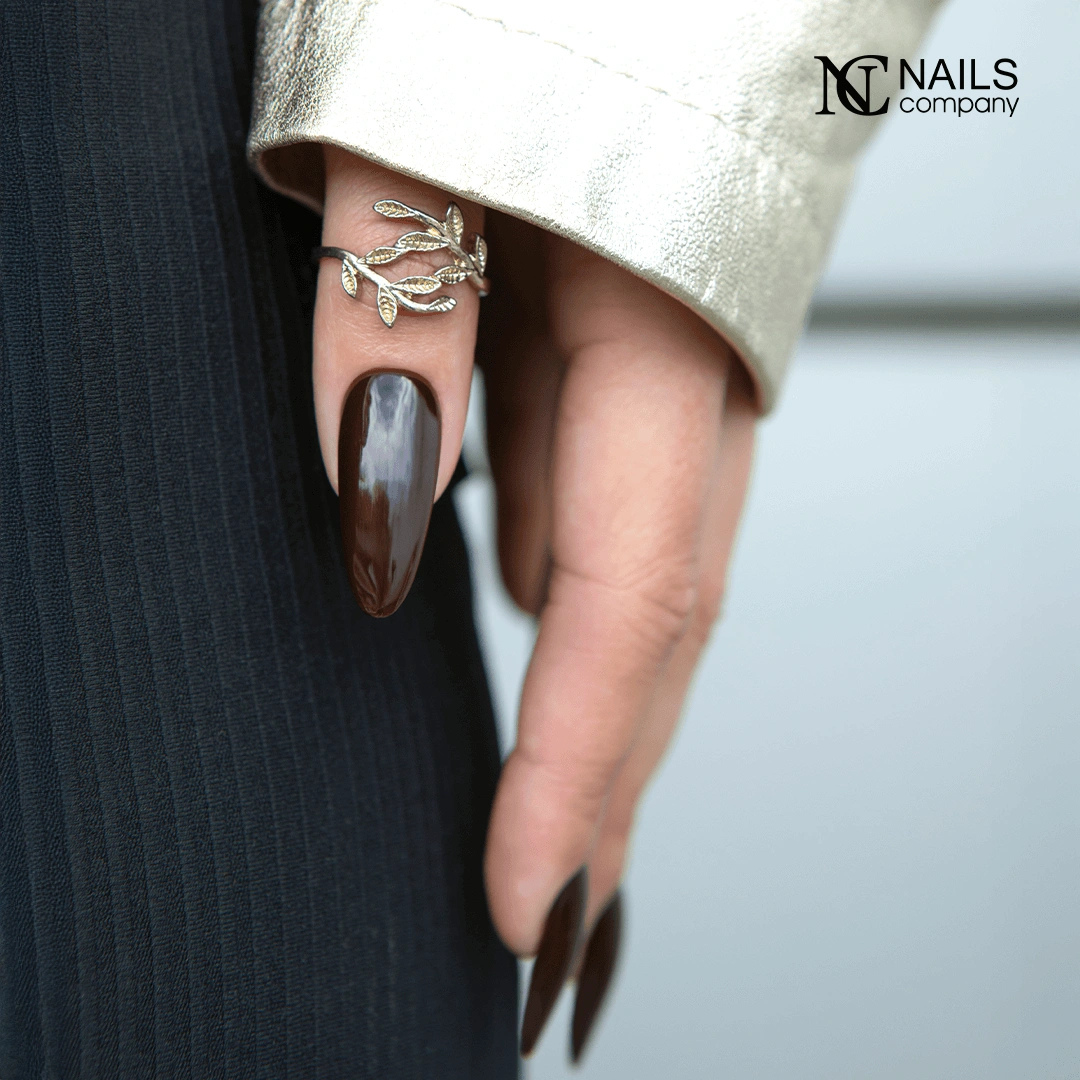 Gel polish Miranda Espresso de Nails Company applique sur une main montrant la couleur brun fonce.