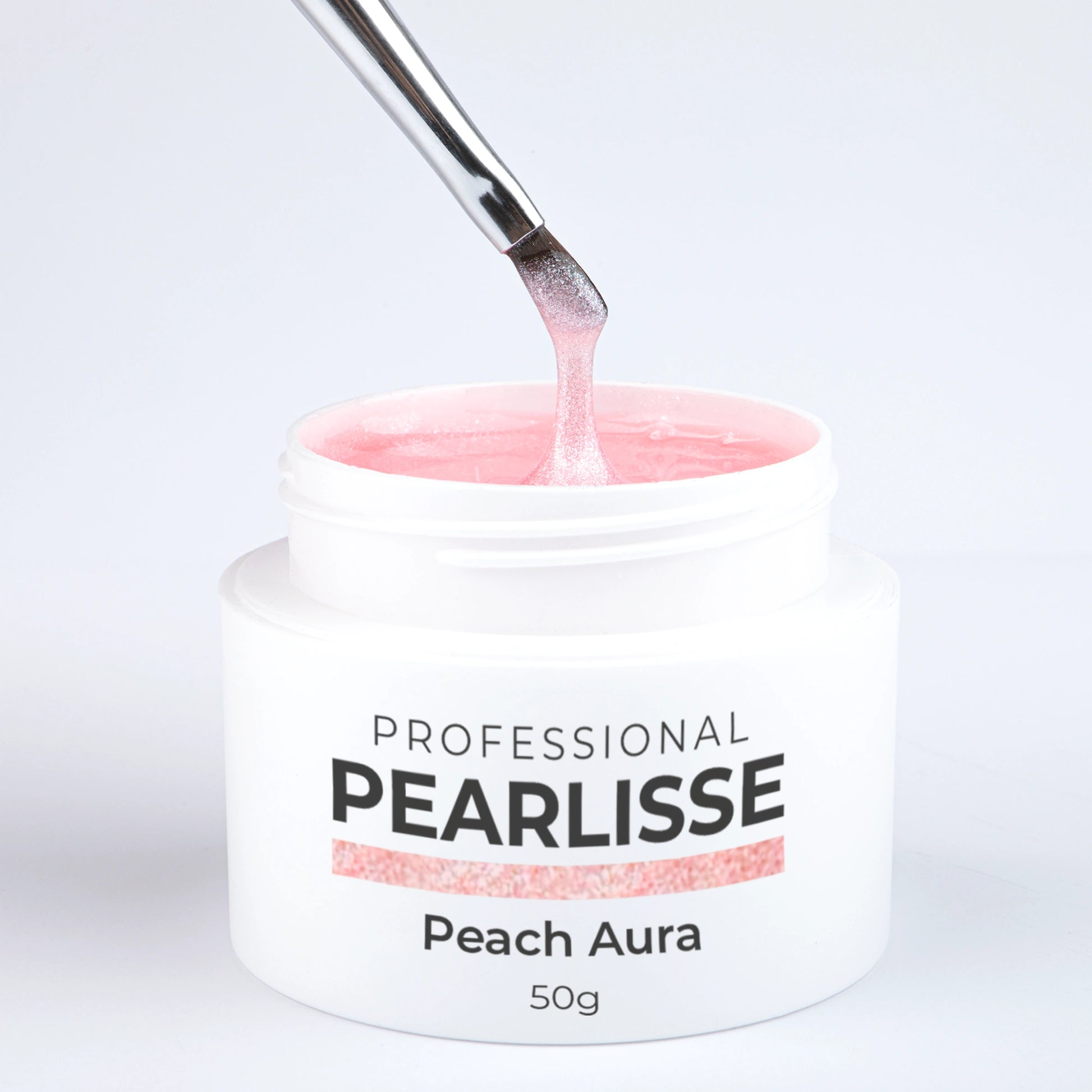 Spatule prélevant le Pearlisse Gel Peach Aura Nails Company dans le pot ouvert avec texture perlée visible.
