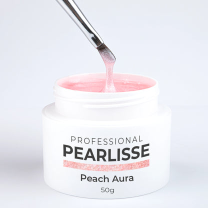 Spatule prélevant le Pearlisse Gel Peach Aura Nails Company dans le pot ouvert avec texture perlée visible.