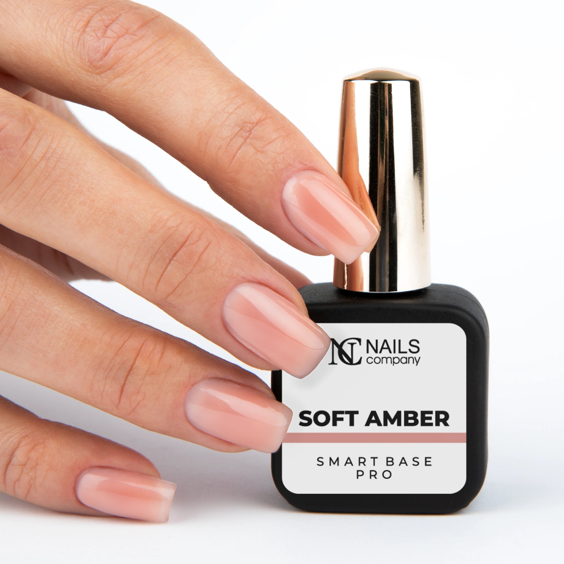 Smart Base Pro Soft Amber Nails Company tenue en main avec couleur beige pêche rosé visible.