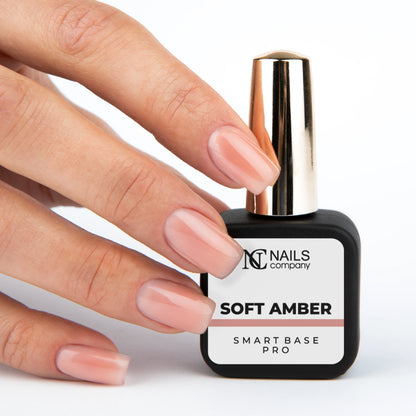 Smart Base Pro Soft Amber Nails Company tenue en main avec couleur beige pêche rosé visible.