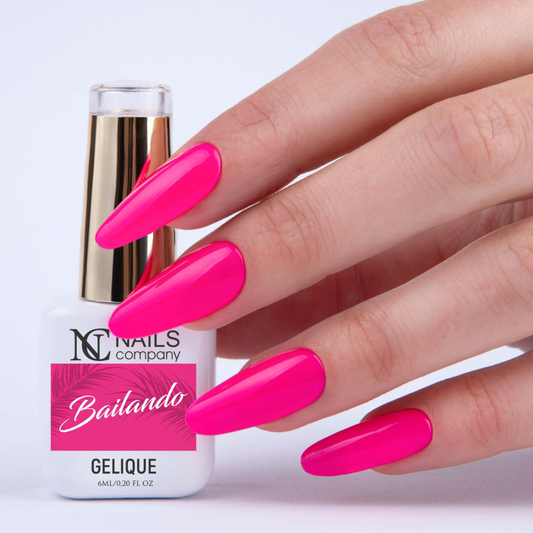 Vernis semi-permanent Bailando de Nails Company en flacon tenu en main, teinte rose néon visible sur l’ongle