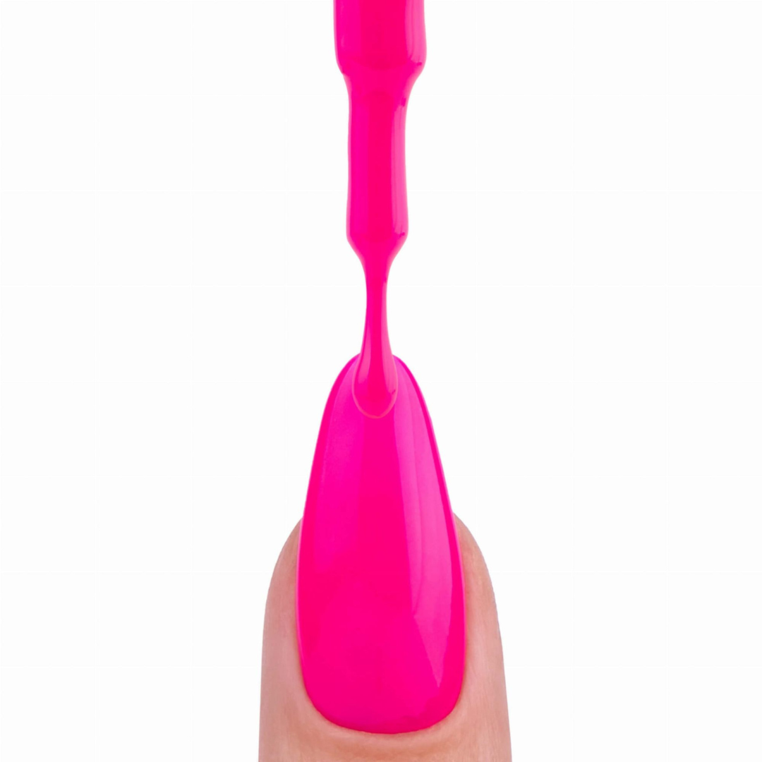 Application du vernis semi-permanent Bailando de Nails Company au pinceau, texture crémeuse rose néon sur le doigt