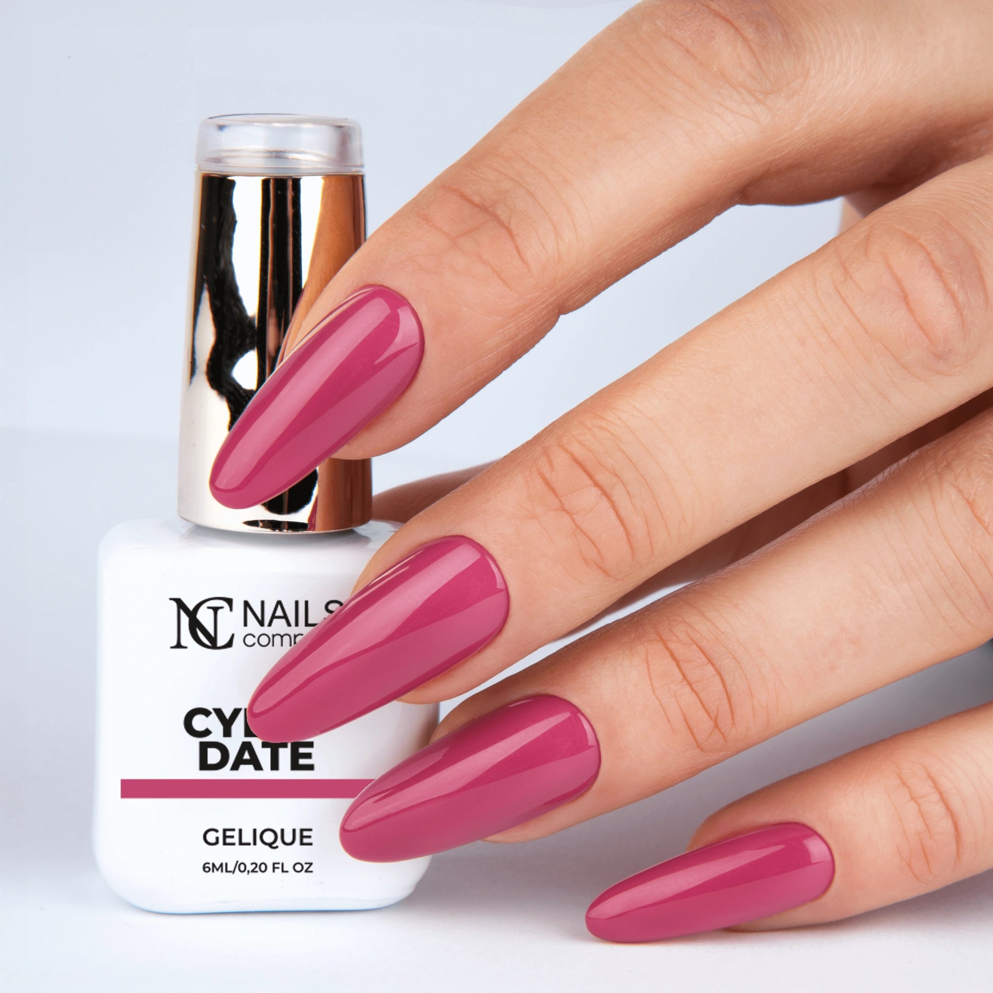 Main tenant le flacon de vernis semi-permanent Cyber Date de Nails Company, teinte rose framboise douce visible