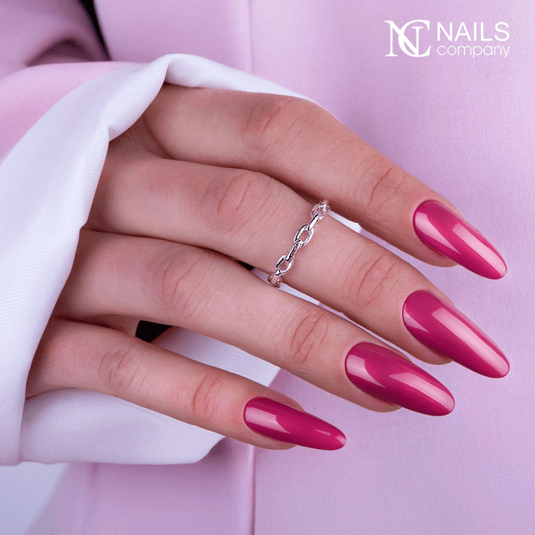 Mains avec le vernis semi-permanent Cyber Date de Nails Company, rose framboise doux appliqué uniformément