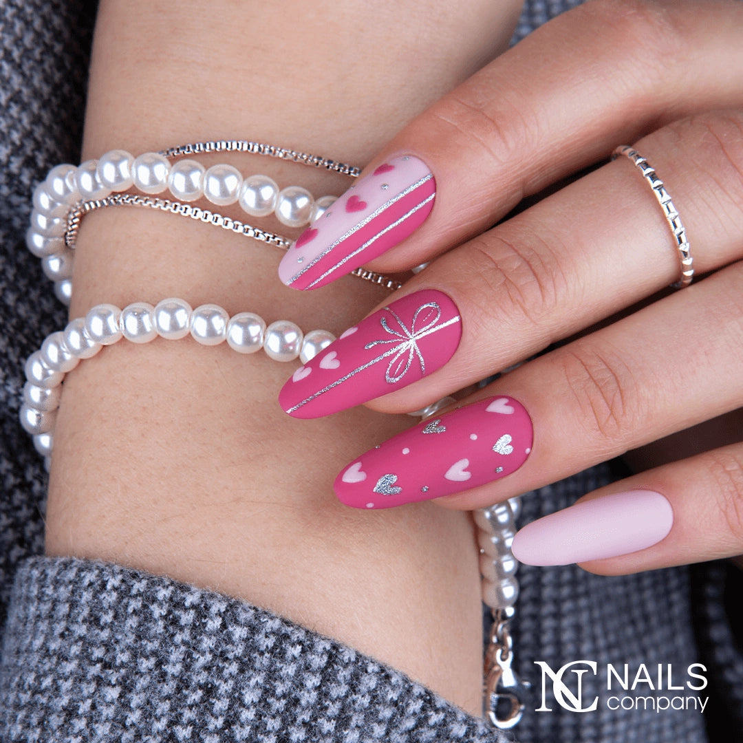 Main avec le vernis semi-permanent Cyber Date de Nails Company, rose framboise doux intégré dans un nail art