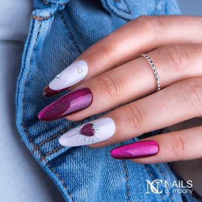 Main avec le vernis semi-permanent Error Kiss de Nails Company, rouge violacé cat eye travaillé avec un motif magnétique