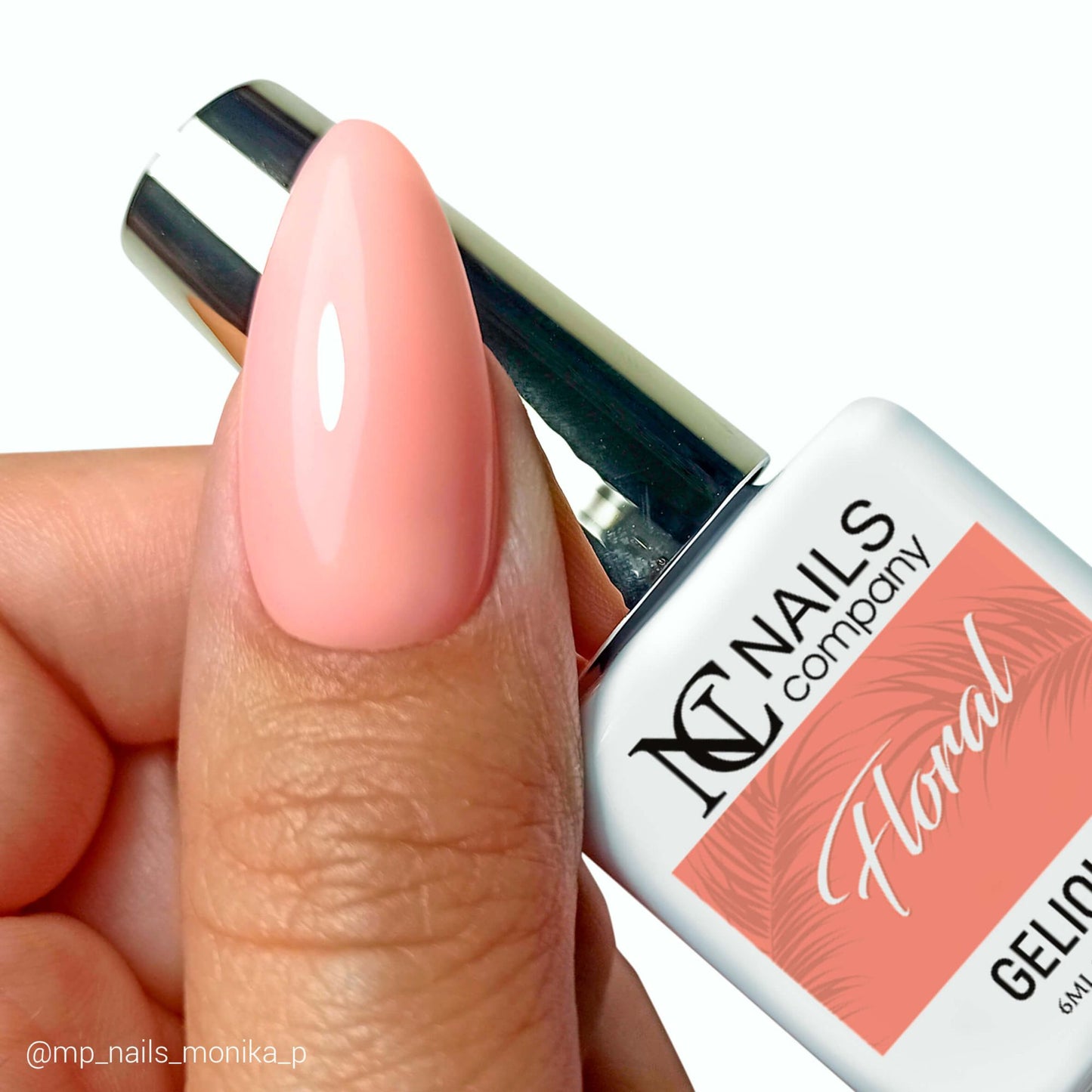 Vernis semi permanent Floral Nails Company corail semi transparent tenu en main avec tip et couleur visible.