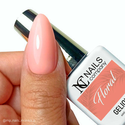 Vernis semi permanent Floral Nails Company corail semi transparent tenu en main avec tip et couleur visible.