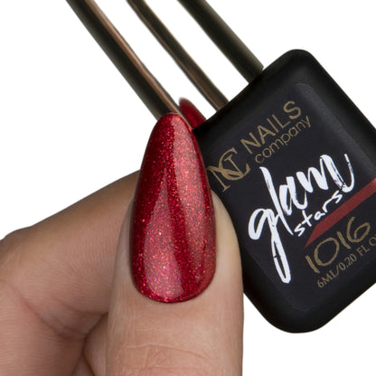 Main avec pouce tenant le flacon de vernis semi-permanent Glam Stars 1016 de Nails Company, collection Glam Stars