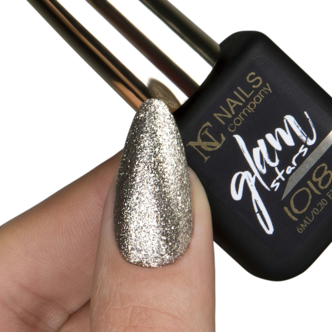 Main tenant le flacon de vernis semi-permanent Glam Stars 1018 de Nails Company, pouce avec doré clair pailleté apparent