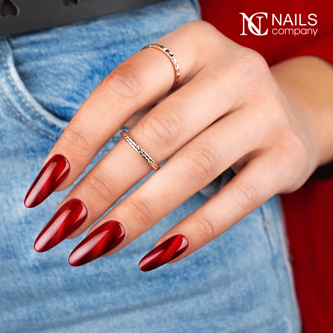 Mains avec le vernis semi-permanent Glow Virus de Nails Company, rouge cat eye à effet lumineux et magnétique