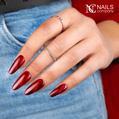 Mains avec le vernis semi-permanent Glow Virus de Nails Company, rouge cat eye à effet lumineux et magnétique