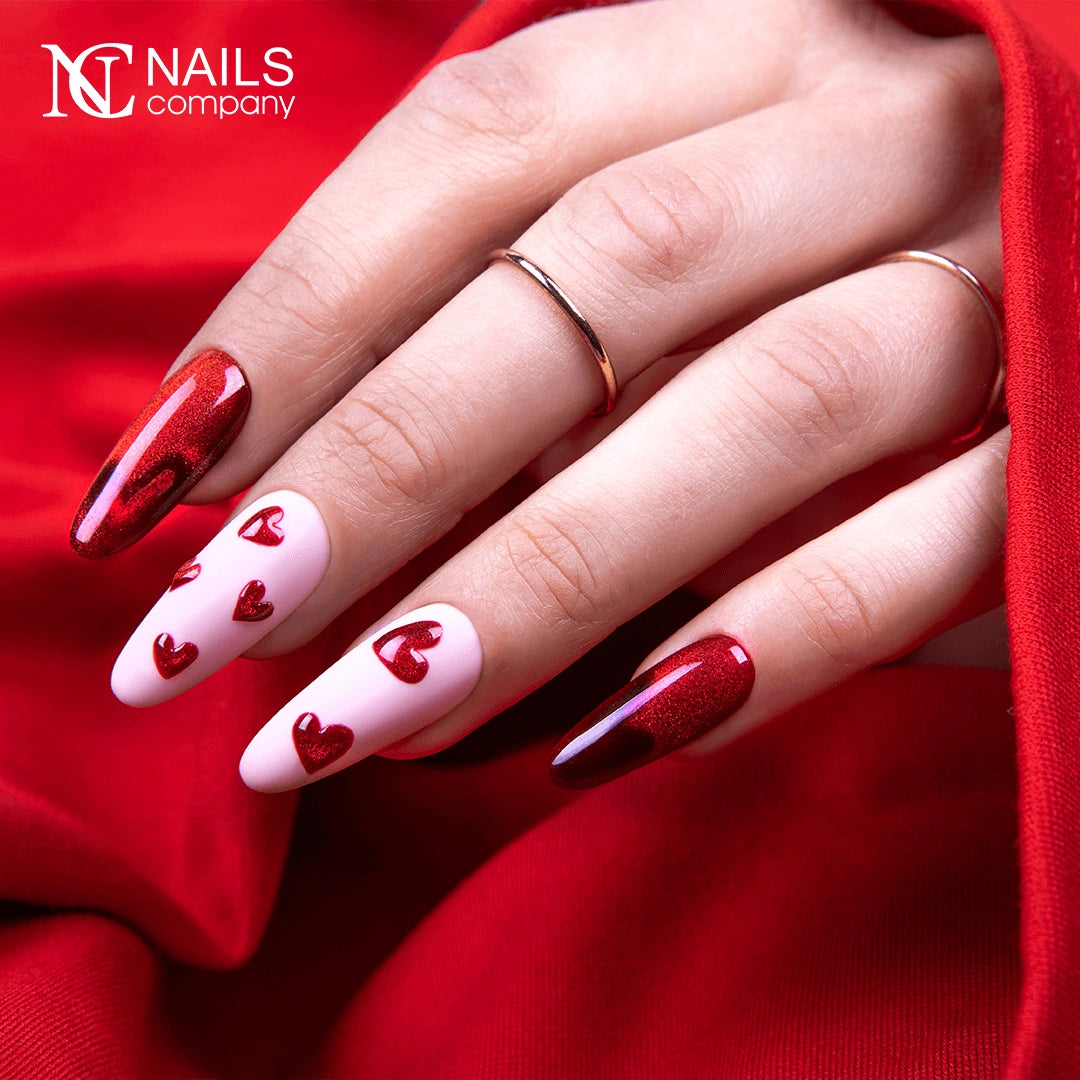 Main avec le vernis semi-permanent Glow Virus de Nails Company, rouge cat eye travaillé avec un motif magnétique