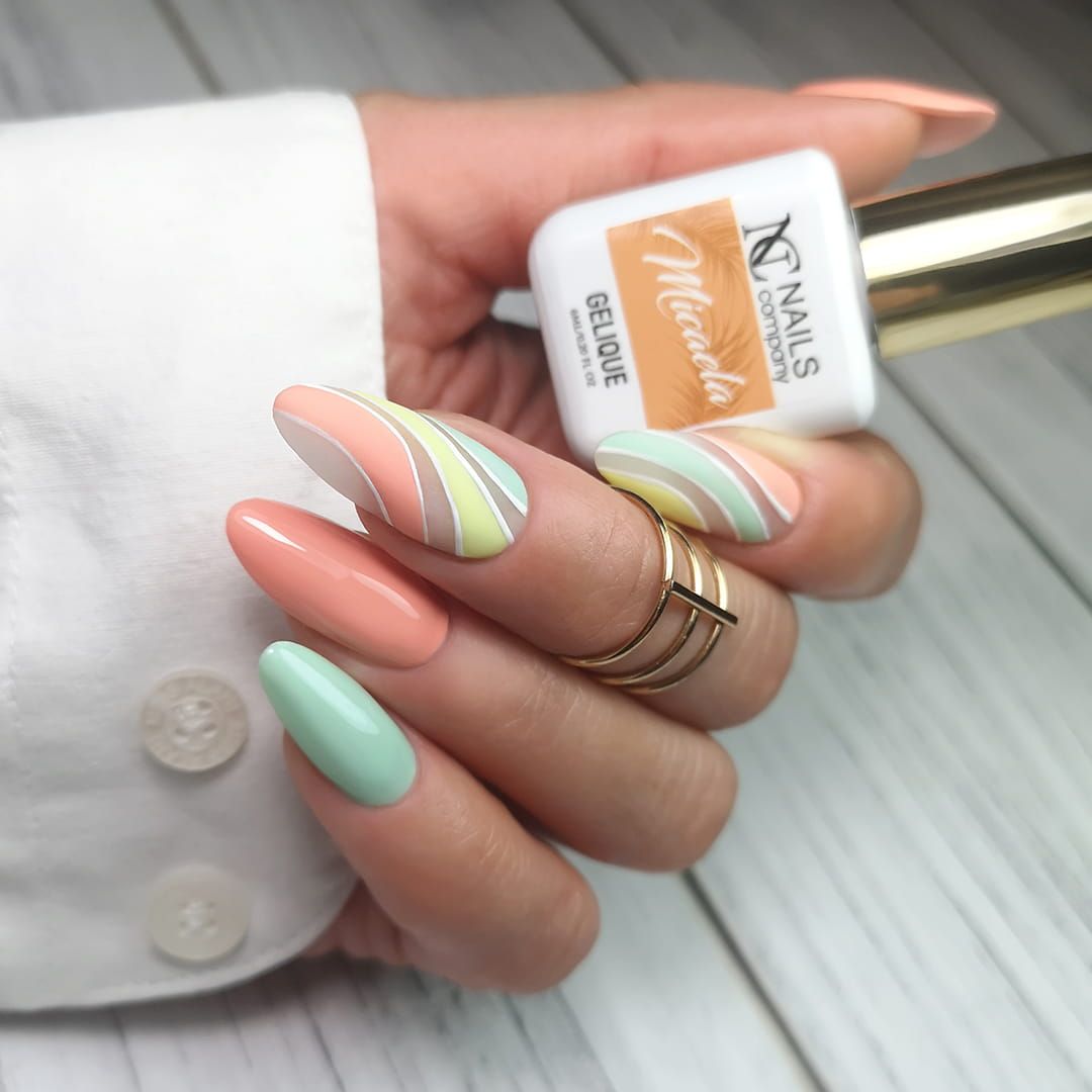 Pose d’ongles avec vernis semi permanent Micaela Nails Company orange pastel doux accompagnée d’un nail art.