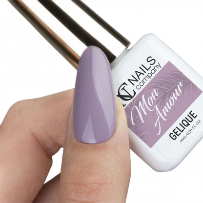 Vernis semi permanent Mon Amour Nails Company tenu avec pouce visible et couleur lavande grisée appliquée.