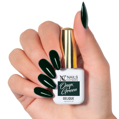 Main tenant le flacon de vernis semi-permanent Onyx Green de Nails Company, vert foncé visible sur ongles naturels