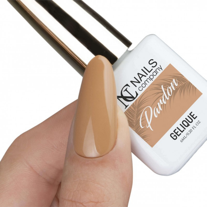 Main avec pouce tenant le flacon de vernis semi-permanent Pardon de Nails Company, collection Je T'aime Paris