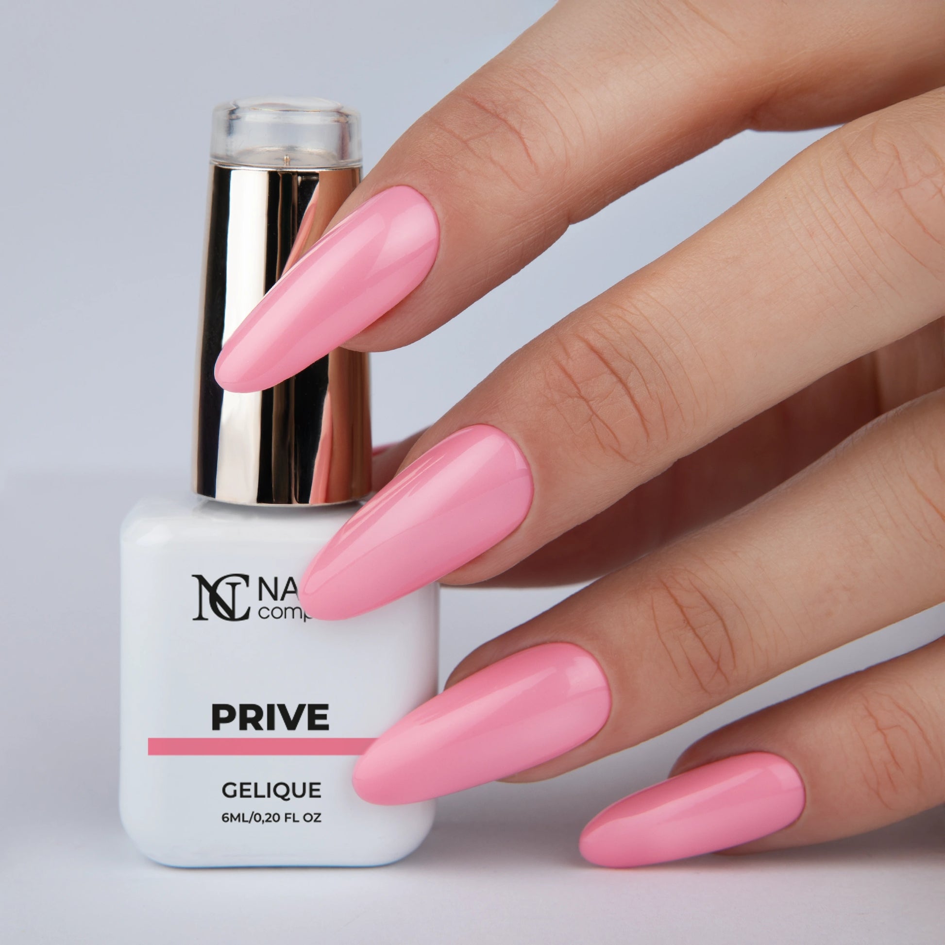 Vernis semi permanent Prive Nails Company rose framboise pastel appliqué sur les ongles, main avec flacon La Petite.