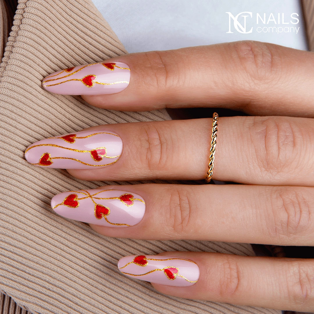 Main avec le vernis semi-permanent Signal Spam de Nails Company, rouge orangé cat eye travaillé avec un motif magnétique