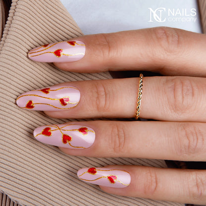 Main avec le vernis semi-permanent Signal Spam de Nails Company, rouge orangé cat eye travaillé avec un motif magnétique