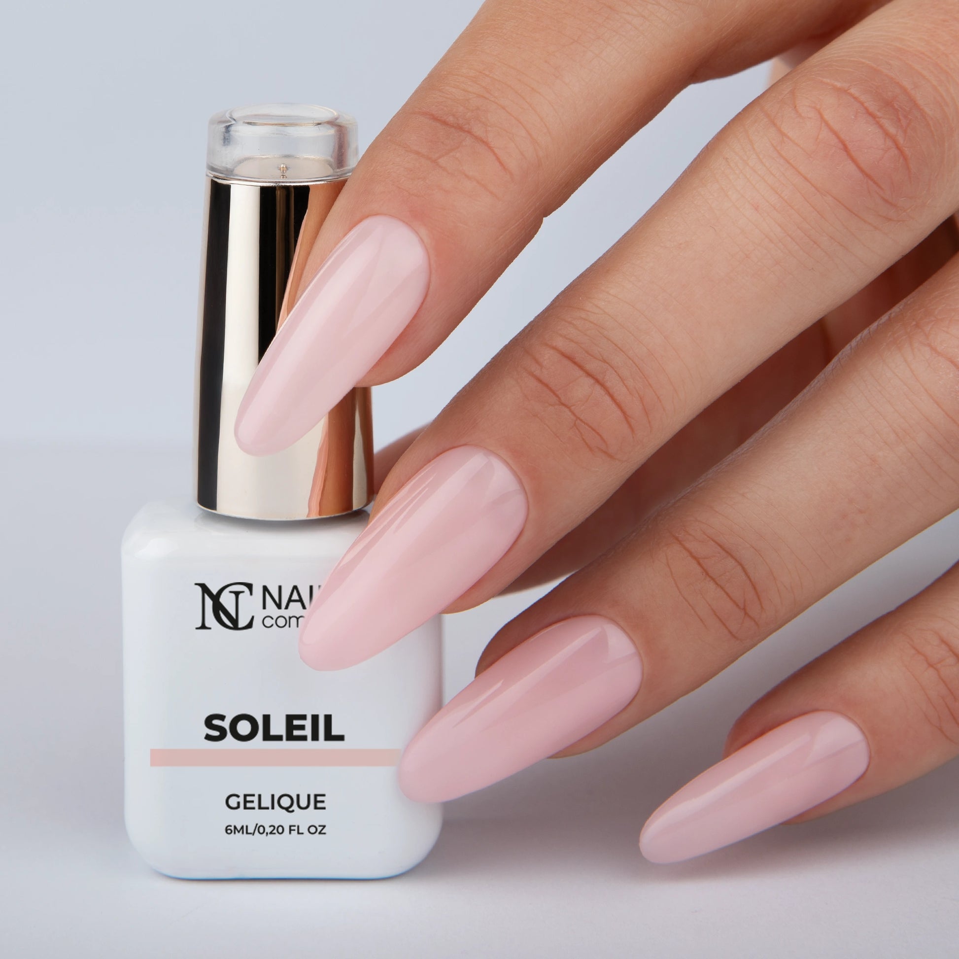 Vernis semi permanent Soleil Nails Company rose clair appliqué sur les ongles, main avec flacon La Petite.