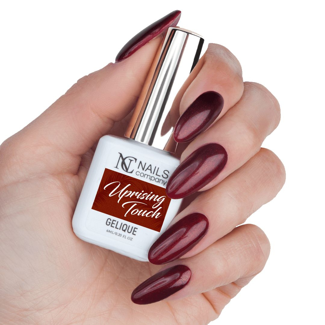 Main tenant le flacon de vernis semi-permanent Uprising Touch de Nails Company, rouge bordeaux à particules sur base sombre