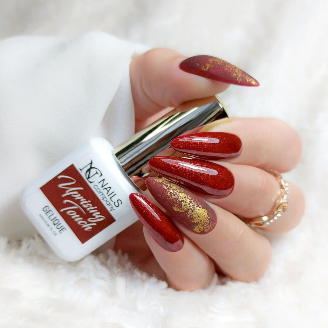 Main présentant le vernis semi-permanent Uprising Touch de Nails Company, rouge bordeaux avec nail art